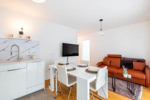 a kitchen and living room with a white table and a couch at GuestReady - Bright getaway near la Défense in Nanterre