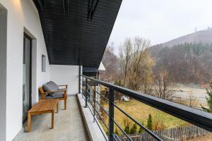 a balcony with a bench and a view of the mountains at Doftana Lake House in Teşila