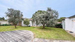 podwórze z dwoma drzewami i domem w obiekcie Villa à proximité de la plage et des commerces w mieście La Couarde-sur-Mer