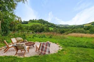 a patio with two chairs and a table in a field at Luxury Eco Escape in South Devon in Darlington