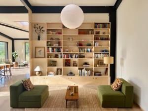 a living room with two green chairs and a book shelf at Luxury Eco Escape in South Devon in Darlington