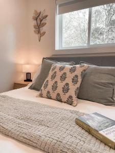 a bedroom with a bed with a book and a window at Elora’s Irvine River Suite in Elora +19 photos