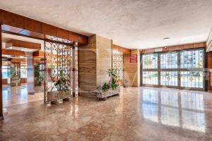 Un vestíbulo vacío con plantas en un edificio. en Seaview coastal apartment in Benalmadena by REMS, en Benalmádena