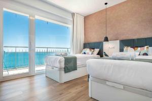 Dos camas en una habitación con vista al mar. en Seaview coastal apartment in Benalmadena by REMS, en Benalmádena 52 fotos más