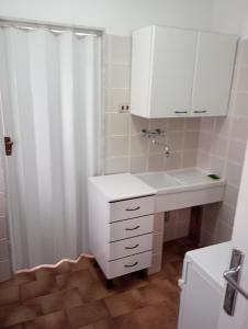 a white bathroom with a sink and a shower at Casa Mariella in Bari +40 photos