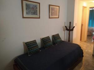 a bedroom with a black bed with four pillows at Departamento Mirasol in Federación