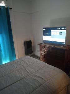 a bedroom with a bed and a television on a dresser at Departamento Mirasol in Federación