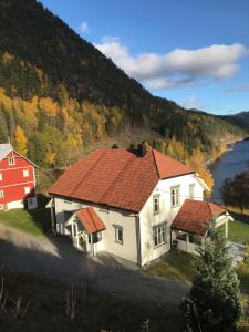 een wit huis met een rood dak naast een meer bij Villa Hegeland in Vråliosen