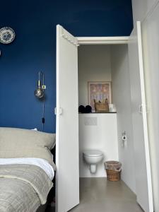 a bedroom with a bed and a toilet at Lovely small apartment in 'De Pijp' in Amsterdam