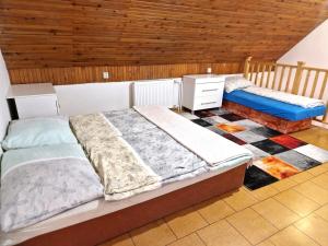 1 Schlafzimmer mit 2 Betten und Holzdecke in der Unterkunft Apartmány Drážovce in Nitra