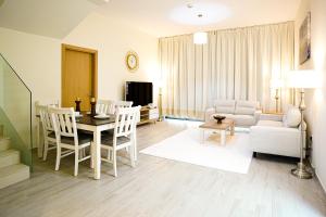 uma sala de estar com uma mesa e cadeiras e um sofá em Luxury Villa by the sea em Fujairah