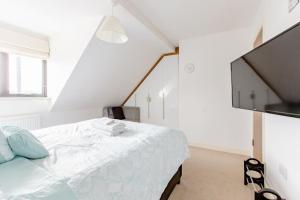 1 dormitorio blanco con 1 cama y TV de pantalla plana en Lovely Comfy Double Bedroom with secure parking, en Bexleyheath