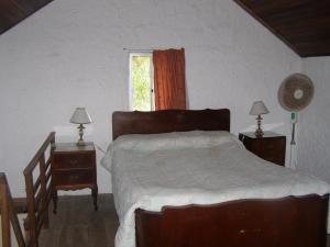 1 dormitorio con 1 cama y 2 mesitas de noche con lámparas en Lambae, en Barra de Valizas