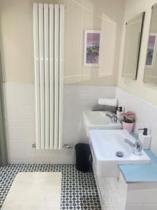 a white bathroom with two sinks and a radiator at William Wallace Hotel in Stirling