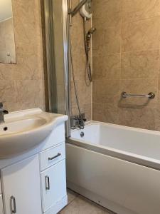 a bathroom with a sink and a tub and a shower at Nice 4 bedroom house in Nottingham