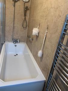 a bathroom with a tub and a shower at Nice 4 bedroom house in Nottingham