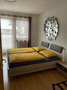 a bedroom with a bed with yellow sheets and a chandelier at Apartment 66 in Bressanone