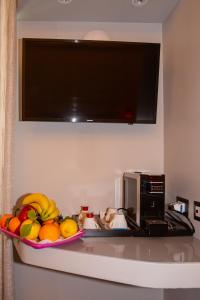 a bowl of fruit on a counter next to a microwave at Corso Suite 107 Rooms Wellness & Spa in Rome