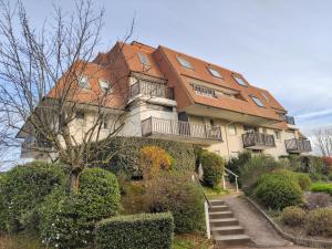 una casa grande con techo rojo en Bel appartement refait à neuf, calme et ensoleillé, en Cabourg