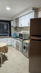 eine Küche mit einem Kühlschrank, einer Waschmaschine und einem Trockner in der Unterkunft Medina 1 in Fès