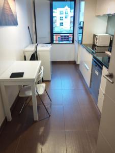 a kitchen with a desk and a table and a window at BEAU APPARTEMENT in Suresnes