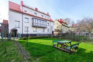a picnic table in the grass in front of a building at Feel like home Apartment SELF CHECK IN in Klaipėda
