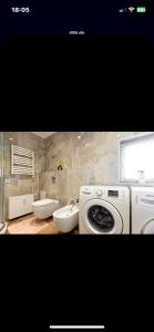 a bathroom with a washing machine and a sink at Feel like home Apartment SELF CHECK IN in Klaipėda