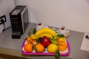 a pink plate of fruit on a desk at Corso Suite 107 Rooms Wellness & Spa in Rome