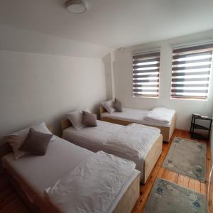 um quarto com três camas e um sofá e duas janelas em Holiday Home White Rose em Barice