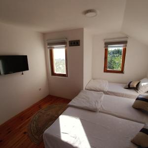 um quarto com 2 camas e uma televisão de ecrã plano em Holiday Home White Rose em Barice