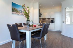 a dining room with a table and chairs and a kitchen at Haus Jensen 2 in List