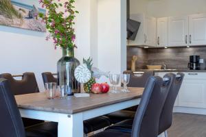 a dining room table with wine glasses and a vase with flowers at Haus Jensen 2 in List