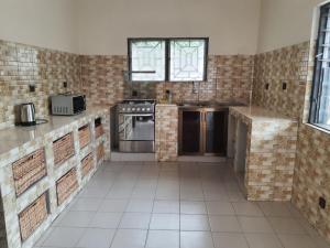 a large kitchen with a stove and a sink at Appartement Seth in Lomé