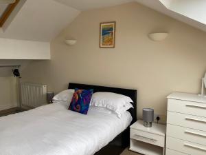 a bedroom with two beds and a dresser at Shore Enough - Morecambe Sea Front Apartment in Heysham