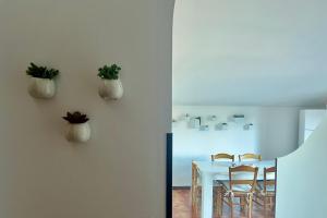 a dining room with a table with chairs and plants on the wall at B&B Villa Reginella in Agerola