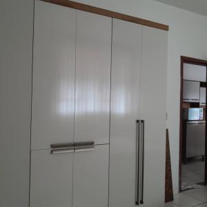 a white cabinet with a door in a kitchen at Apartamento inteiro e climatizado in Ipatinga