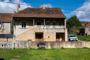 een oud huis met een veranda en een wit hek bij Wine-grower's House At Pras-burgundy in Genouilly