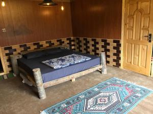 a bed in a room with a door and a rug at Hunza Verse in Hunza