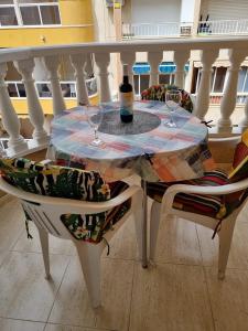 トレビエハにあるlos locos San Pascualのテーブル(椅子2脚付)とワイン1本