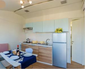 uma cozinha com uma mesa e um frigorífico branco em EUROCAMPINGPACENGO em Pacengo di Lazise