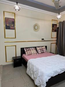 a bedroom with a bed and two pictures on the wall at As résidence meublée AM in Ouagadougou