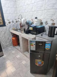 a kitchen with a counter and a refrigerator in it at As résidence meublée AM in Ouagadougou