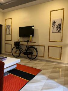 a bike parked in a room with a tv at As résidence meublée AM in Ouagadougou