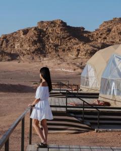 Una donna con un vestito bianco sulle scale nel deserto di Rum Mars camp a Wadi Rum