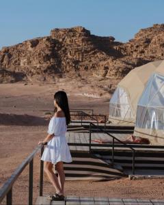 a woman in a white dress standing on steps in the desert at RUM MOON lUXURY CAMP in Wadi Rum