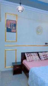 a bedroom with two beds and a nightstand next to it at As résidence meublée AM in Ouagadougou