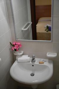 a bathroom sink with a vase of flowers on it at B&B Fort Apache in Monforte San Giorgio