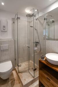 ein Bad mit einer Dusche, einem WC und einem Waschbecken in der Unterkunft Haus Dorfglück in Morsum