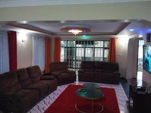 Sala de estar con 2 sofás y mesa en Radisson Villa, en Kisumu