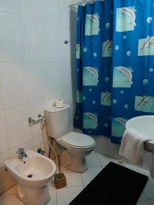 baño con aseo y cortina de ducha azul en أجنحة أبو قبع الفندقيةAbu Quboh Hotel Suite Apartment en Amán